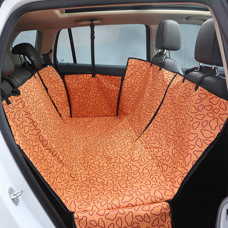 Funda naranja estampada para proteger los asientos traseros del coche al viajar con perros