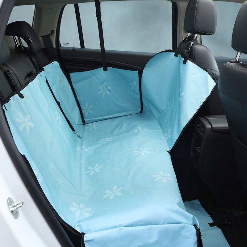 Funda azul con estampado floral para proteger los asientos traseros del coche al viajar con perros